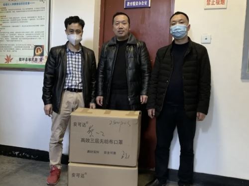 黎定亮将3500只口罩交到镇坪县教育体育局工作人员手上（左一为黎定亮）